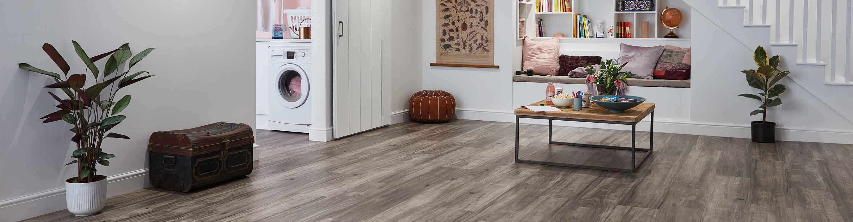 Vinyl flooring in finished basement with reading nook, laundry room and potted plants